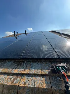 Zonnepanelen op een schuin dak tijdens professionele reiniging