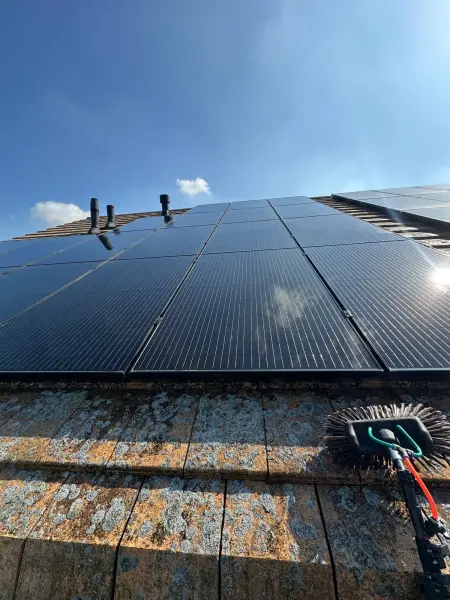 Zonnepanelen op een schuin dak tijdens professionele reiniging