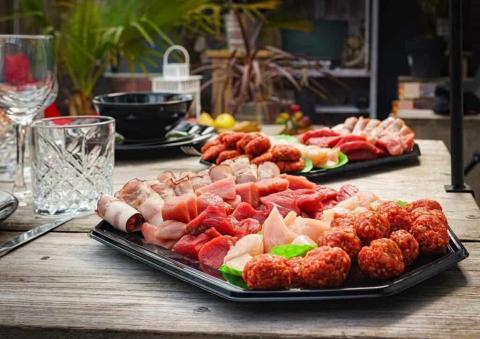 Gourmetpakket op schaal op een tafel met daarop glazen
