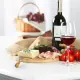 Een fles wijn, een glas wijn, tomaten, kaas en ham staan op tafel.