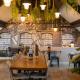 Gezellige eethoek met planten en houten tafels.